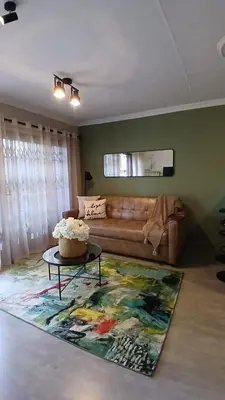 a living room with a couch and a table at Iris HAVEN feel at home in Pretoria