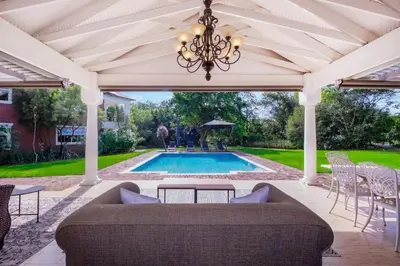 a patio with a couch and a table and a pool at Manor On Main in Midrand