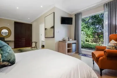 a bedroom with a large bed and a large window at Manor On Main in Midrand