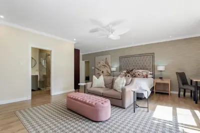 a living room with a couch and a bed at Manor On Main in Midrand