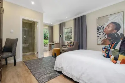 a bedroom with a bed and a living room at Manor On Main in Midrand