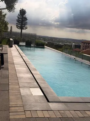 a swimming pool with blue water in a yard at Riviera Château de Rêve - Phoenix's Gîte at Ellipse Waterfall, Midrand in Midrand