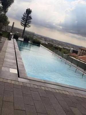 a large swimming pool with blue water in a building at Riviera Château de Rêve - Phoenix's Gîte at Ellipse Waterfall, Midrand in Midrand