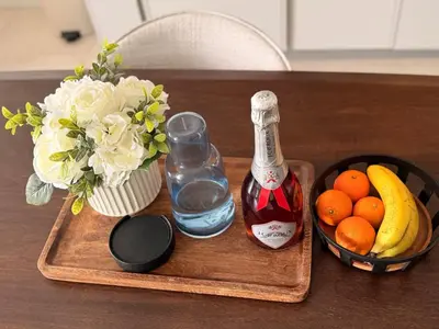 a wooden tray with a bottle of alcohol and a vase of fruit at Riviera Château de Rêve - Phoenix's Gîte at Ellipse Waterfall, Midrand in Midrand