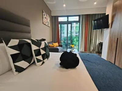 a hotel room with a large bed with pillows at Comfort at 35 Menlyn Maine Residences in Pretoria