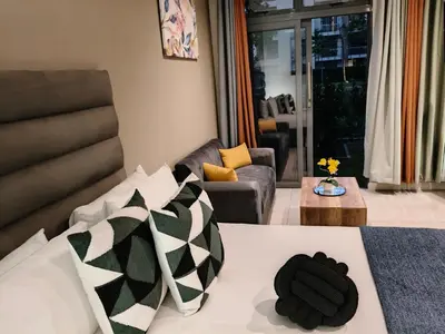 a living room with a bed and a couch at Comfort at 35 Menlyn Maine Residences in Pretoria