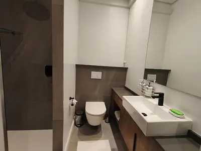 a bathroom with a white toilet and a sink at Comfort at 35 Menlyn Maine Residences in Pretoria