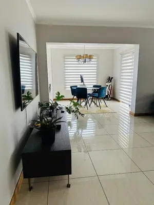 a living room with a dining room table and chairs at Casa Maison - Stylish 3 Bedroom in Summerset, Midrand in Midrand
