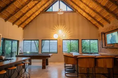 a large room with a bar and some windows at Timlia Marloth Park in Marloth Park