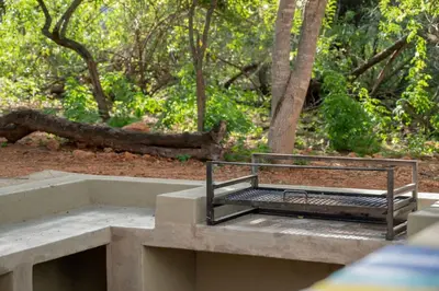 a bench sitting on top of a concrete structure at Timlia Marloth Park in Marloth Park