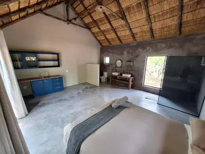 a large room with a bed and a sink at Timlia Marloth Park in Marloth Park