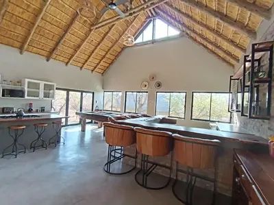a large kitchen with a bar and a pool table at Timlia Marloth Park in Marloth Park