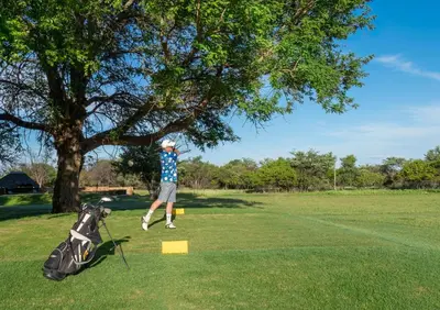 a man hitting a golf ball on a golf course at Babirwa in Rooiberg