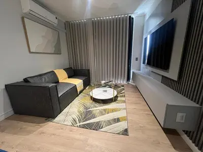 a living room with a couch and a tv at Havana at Ellipse Waterfall in Midrand