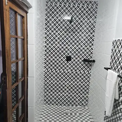 a bathroom with a shower with a black and white tile at 14 Isabel Room 2 in Centurion