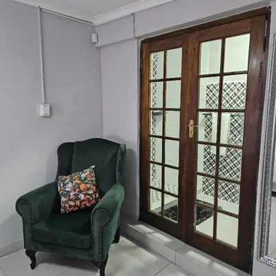 a green chair with a pillow sitting next to a window at 14 Isabel Room 2 in Centurion