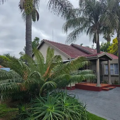 a house with palm trees in front of it at 14 Isabel Room 2 in Centurion