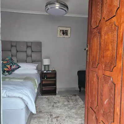 a bedroom with a bed and a wooden door at 14 Isabel Room 2 in Centurion