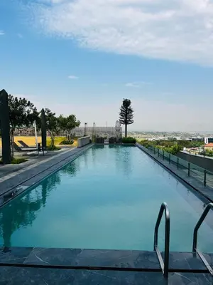 a large swimming pool with blue water at Ellipse Waterfall 2BR with Pool, Restaurant & Gym in Midrand