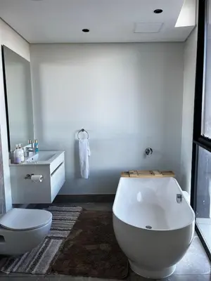 a bathroom with a tub and a toilet and a sink at Ellipse Waterfall 2BR with Pool, Restaurant & Gym in Midrand