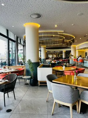 a restaurant with tables and chairs and a cafeteria at Ellipse Waterfall 2BR with Pool, Restaurant & Gym in Midrand