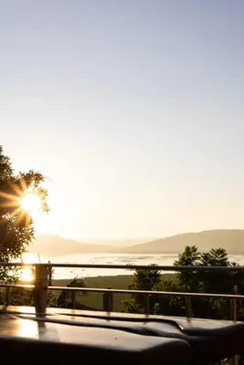 a view of the ocean from a balcony at sunset at Shekinah Cabin in Hartbeespoort