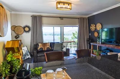 a living room with a couch and a television at Shekinah Cabin in Hartbeespoort