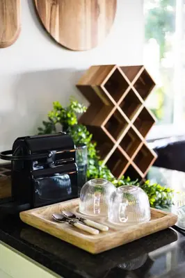 a cutting board with wine glasses on a counter at Shekinah Cabin in Hartbeespoort