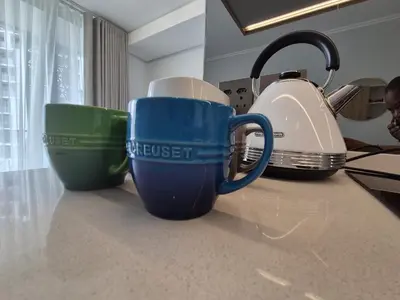 three coffee cups sitting on a kitchen counter at One Palm at Ellipse Waterfall in Midrand