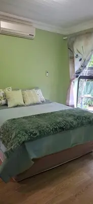 a bedroom with a bed and a window with a fan at Olive Studio in Pretoria
