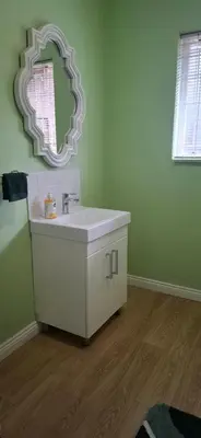 a bathroom with a white sink and a mirror at Olive Studio in Pretoria