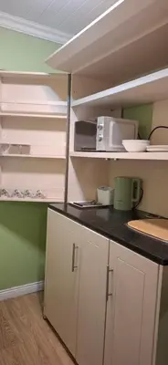 a kitchen with white cabinets and a counter top at Olive Studio in Pretoria