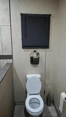 a small bathroom with a toilet and a window at ColtsRest in White River