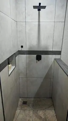 a shower stall with a glass door and a shower at ColtsRest in White River