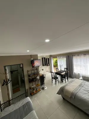 a bedroom with a bed and a table and chairs at ColtsRest in White River