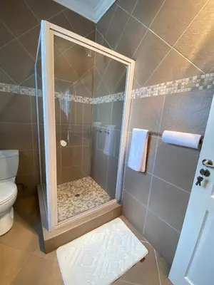 a shower with a glass door in a bathroom at Asanda Retreat in Kempton Park