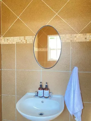 a bathroom sink with a mirror and a towel at Asanda Retreat in Kempton Park