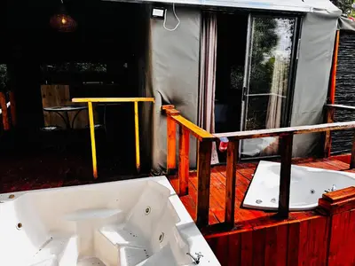 a bath tub on a deck with a tent at Thaba View Luxury Tent in Hartbeespoort