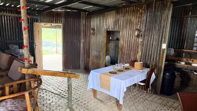 a dining room with a table with a white table cloth at Rocks & Roses SinknBlink in Lochiel