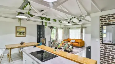 a kitchen and living room with a brick wall at Cottage Daisy in Doornrandjies