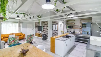 a kitchen and living room with a couch and a table at Cottage Daisy in Doornrandjies