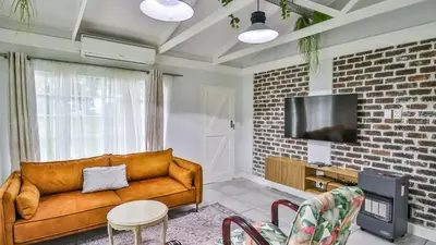 a living room with a couch and a tv at Cottage Daisy in Doornrandjies