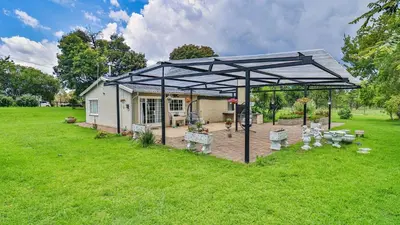 a pavilion in a yard in front of a house at Cottage Daisy in Doornrandjies