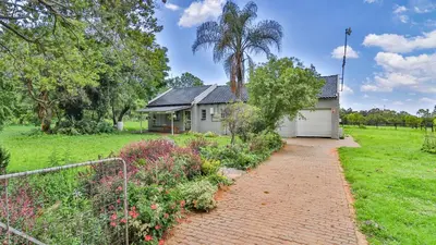 a house with a brick path in front of a yard at Cottage Protea in Doornrandjies