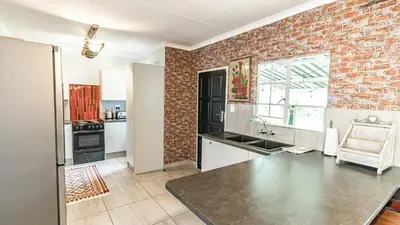 a kitchen with a brick wall at Cottage Protea in Doornrandjies