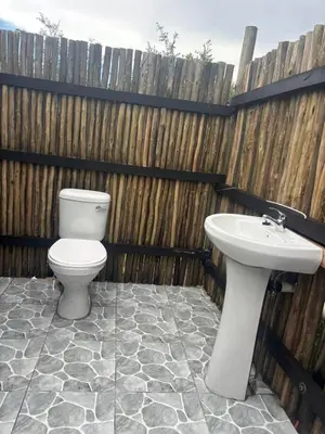 a bathroom with a toilet and a sink at Inn Africa Safari Camp in Welverdiend