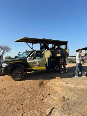 a green and yellow jeep parked in the dirt at Inn Africa Safari Camp in Welverdiend
