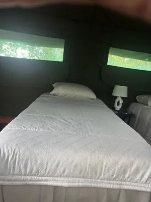 a white bed in a room with two windows at Inn Africa Safari Camp in Welverdiend