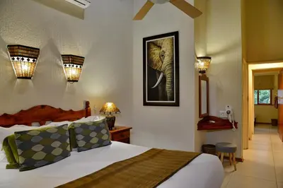a bedroom with a bed with a picture of an elephant at Cambalala - Luxury Units - in Kruger Park Lodge - Serviced Daily, Free Wi-Fi in Hazyview