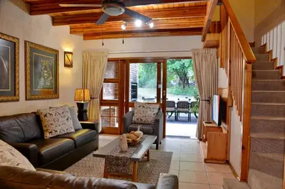 a living room with a couch and a tv at Cambalala - Luxury Units - in Kruger Park Lodge - Serviced Daily, Free Wi-Fi in Hazyview